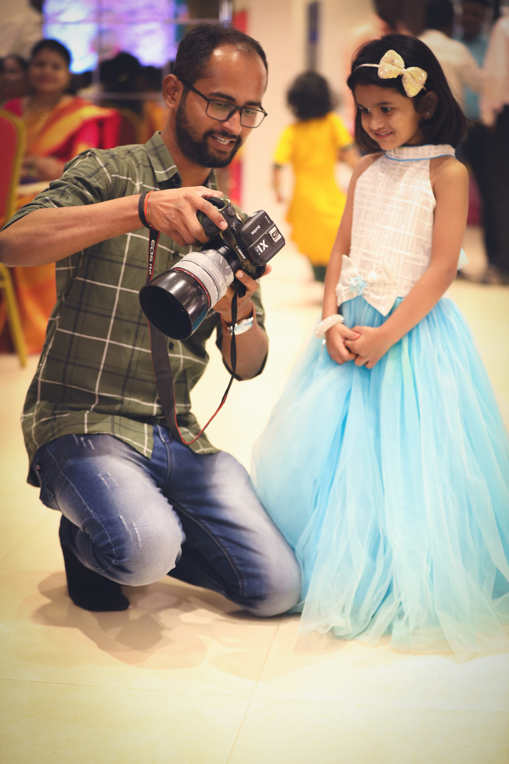 Mayur Wairkar showing a photograph on his Canon camera to a curious little girl